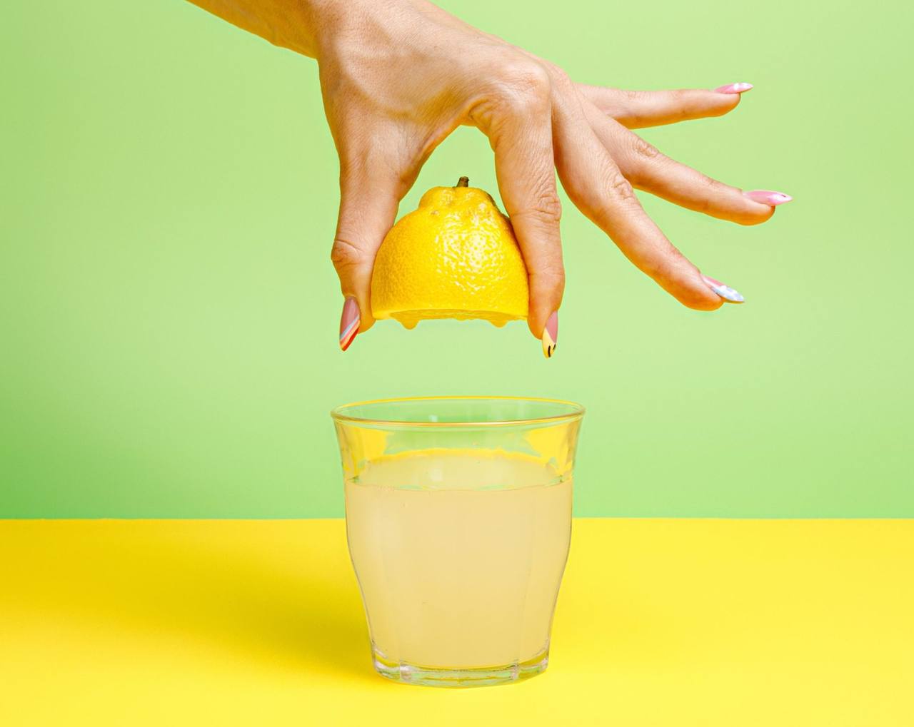 Raka što cedi polovina limon nad čaša limonada